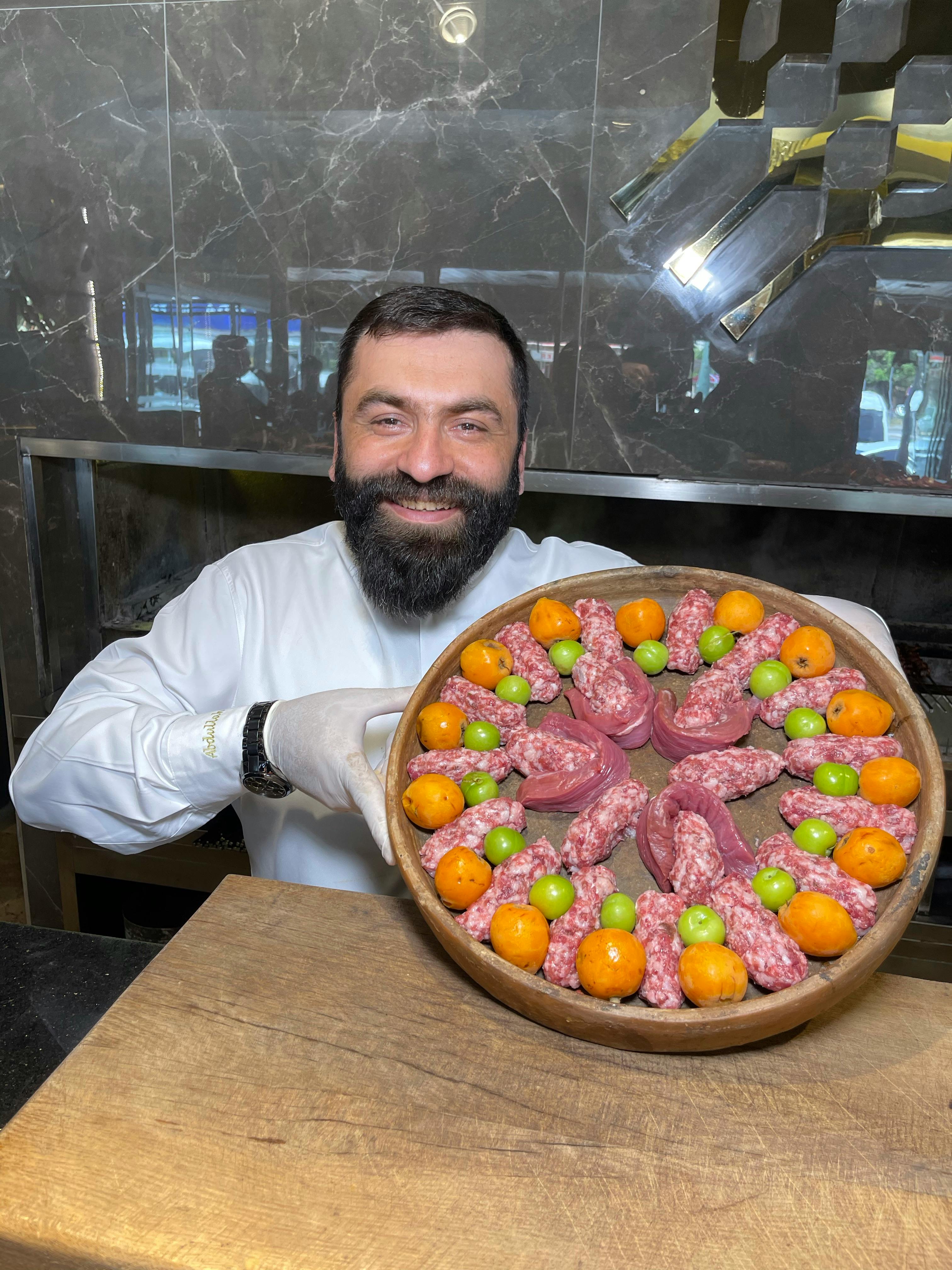 A vibrant and inviting image of a Chef preparing a delicious meal in a modern kitchen, symbolizing Food Inc.'s dedication to culinary excellence and fresh food preparation. The chef is smiling, wearing a white uniform and hat, surrounded by fresh ingredients and cooking utensils, creating an atmosphere of warmth and professionalism.