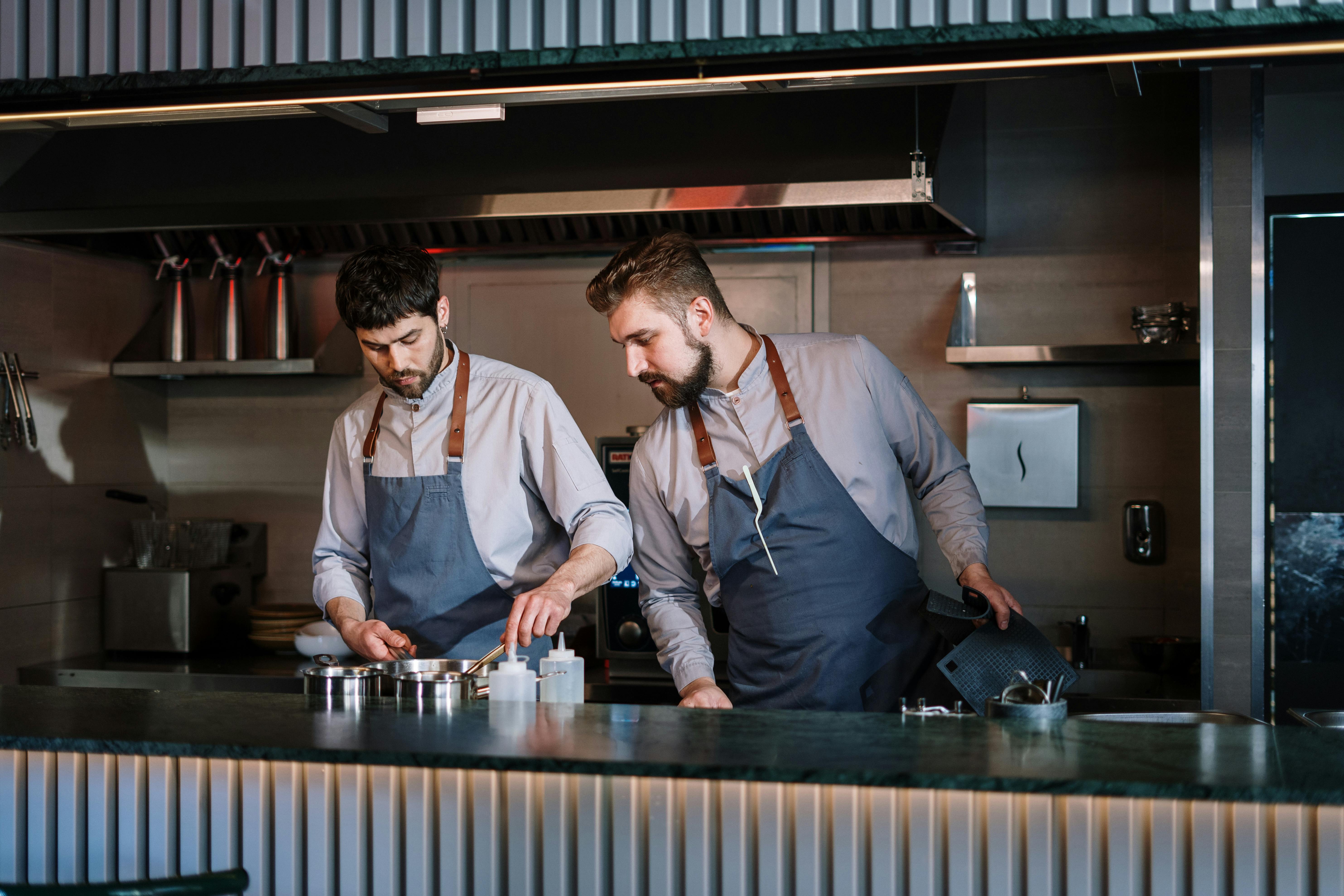 Professional chef in white uniform and hat preparing food in a modern kitchen, representing Food Inc.'s commitment to quality culinary expertise and fresh meal preparation